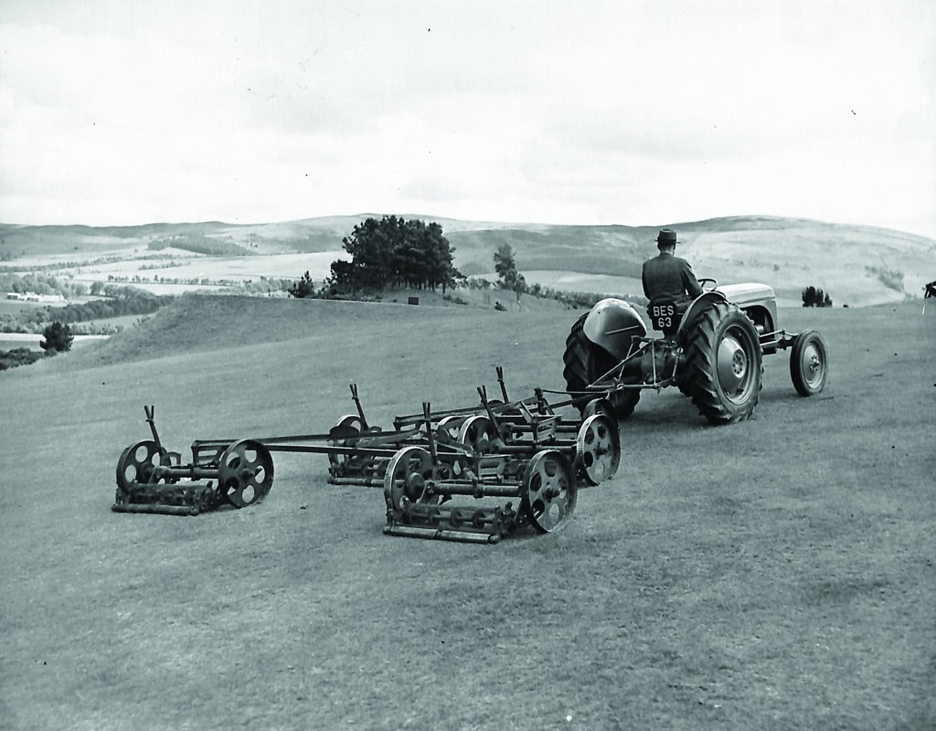 A Greenkeeper at Gleneagles in 1949, using a tractor with gang mower.